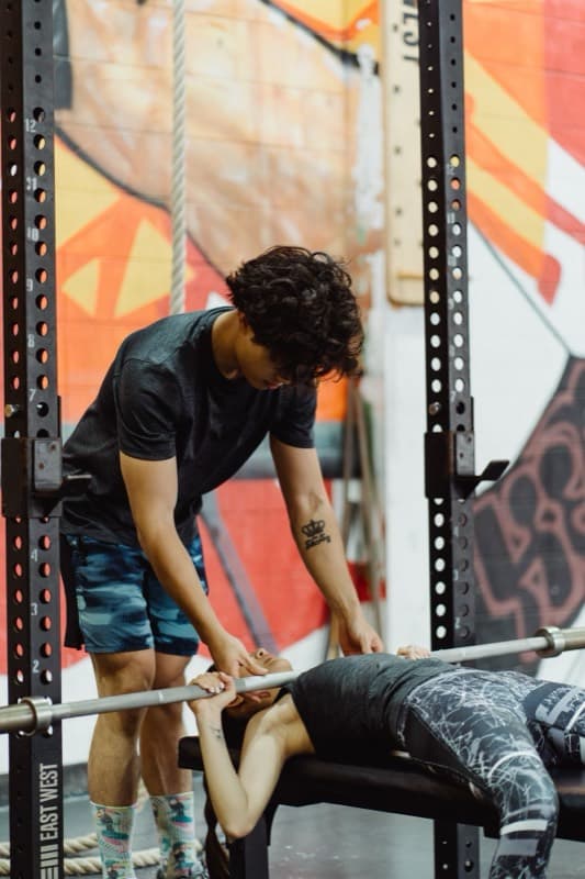 Personal trainer spotting a client on the bench press